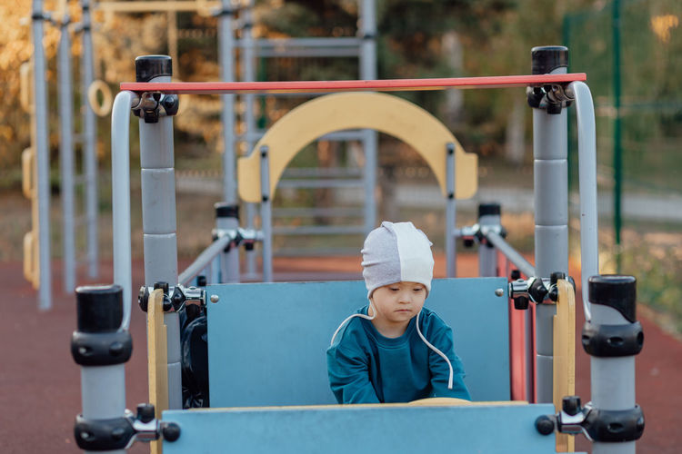 A boy, person with down syndrome walks in the park