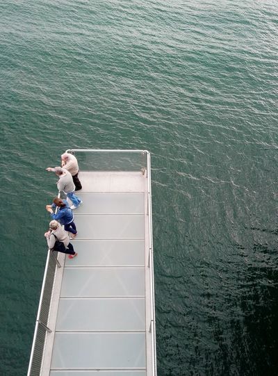 High angle view of people standing on pier over sea