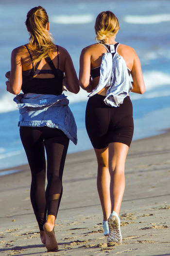 Rear view of women standing on beach