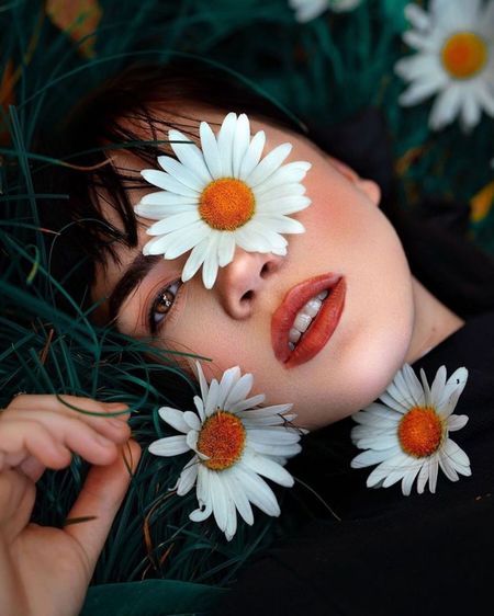 Close-up of beautiful woman lying down amidst flowers