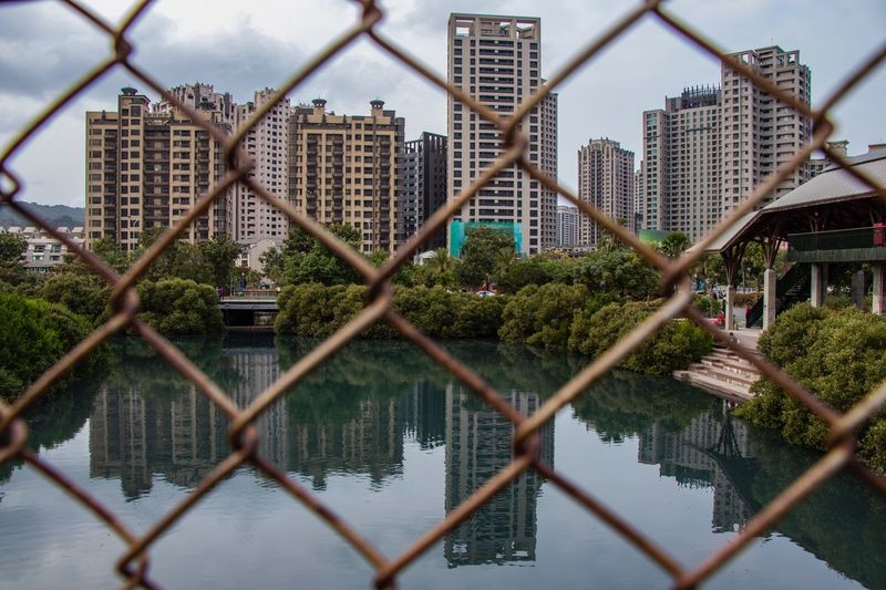 Buildings seen through chainlink fence