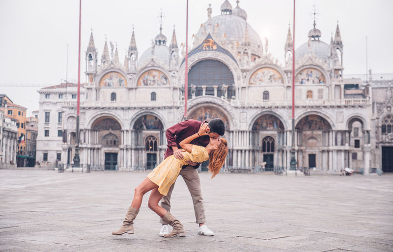 Couple kissing against cathedral