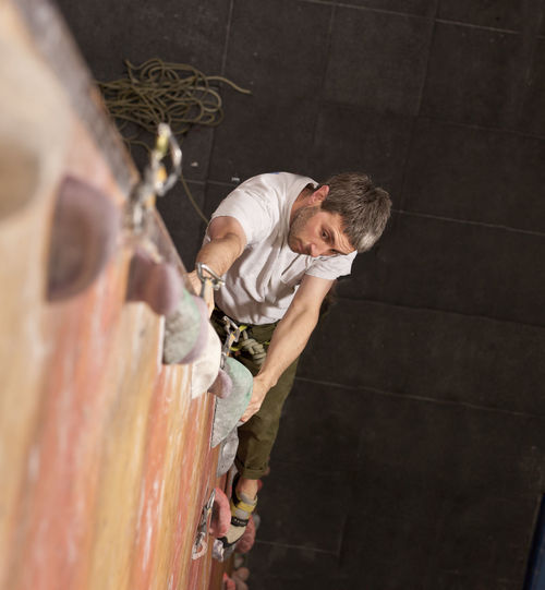 Mature man practising at indoor climbing wall in the uk
