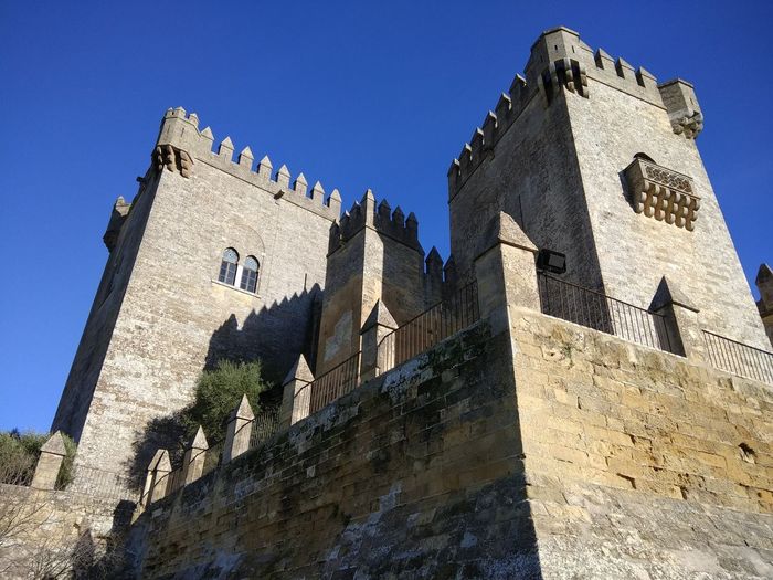 Low angle view of historic building against blue sky