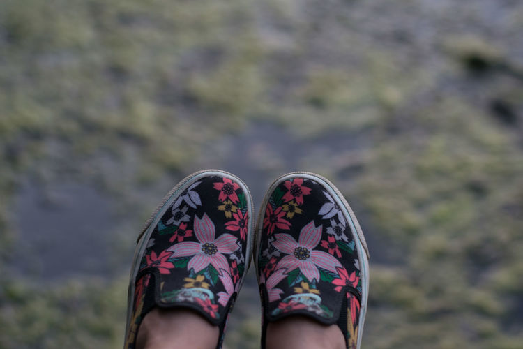 Low section of woman wearing shoes against blurred background