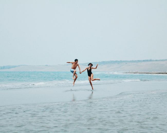 Adult Adults Only Adventure Beach Carefree Couple Day Friendship Healthy Lifestyle Horizon Over Water Jump Leisure Activity Love Nature Outdoors People Sea Sky Sport Togetherness Two People Vacations Weekend Activities Young Adult Young Women