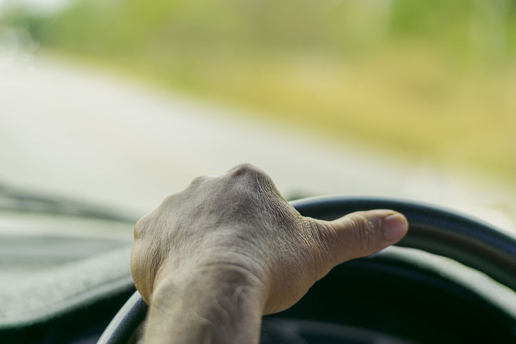 Close-up of person hand driving car