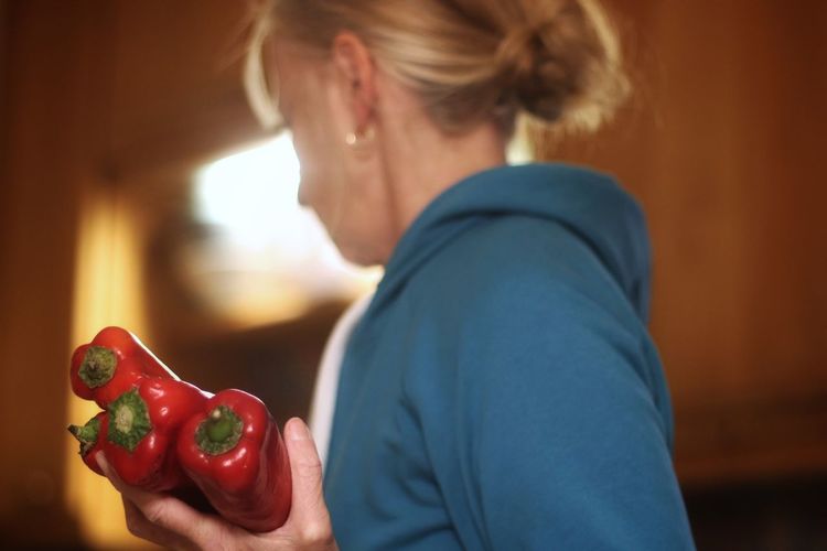 Midsection of woman holding red  bell pepper