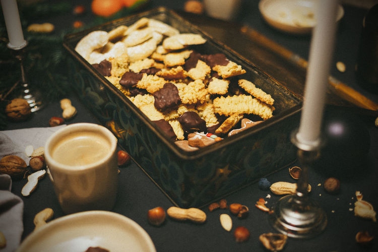 High angle view of christmas cookies in a box on table with coffee