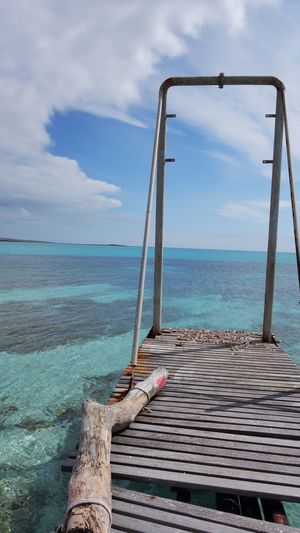 Old pier over sea against sky