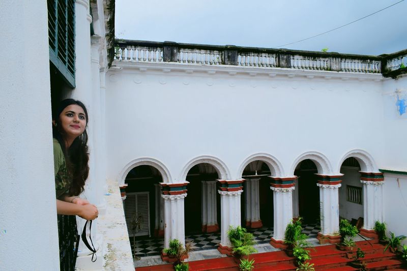 Portrait of woman standing against railing