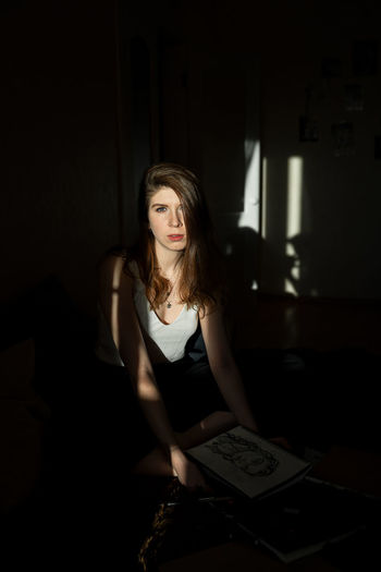 Portrait of woman sitting in darkroom