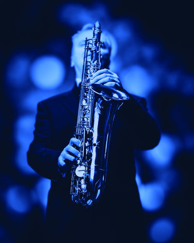 Low angle view of man playing saxophone at music concert