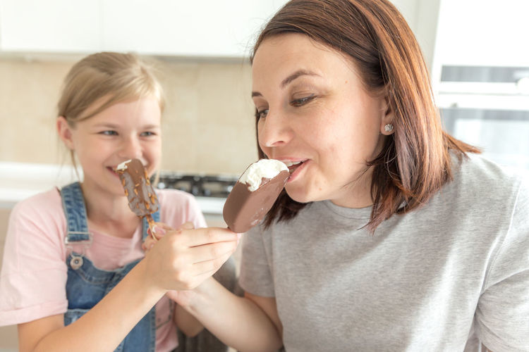 Mother and daughter eating ice cream at home