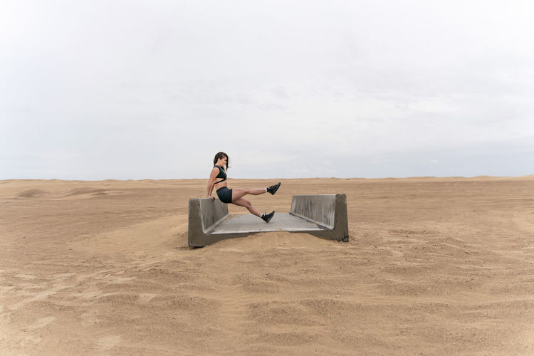 Woman sitting on chair in desert