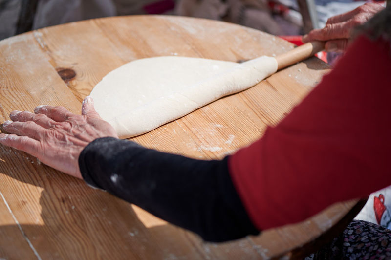Cooking a traditional turkish dish by hand with a wooden rolling pin