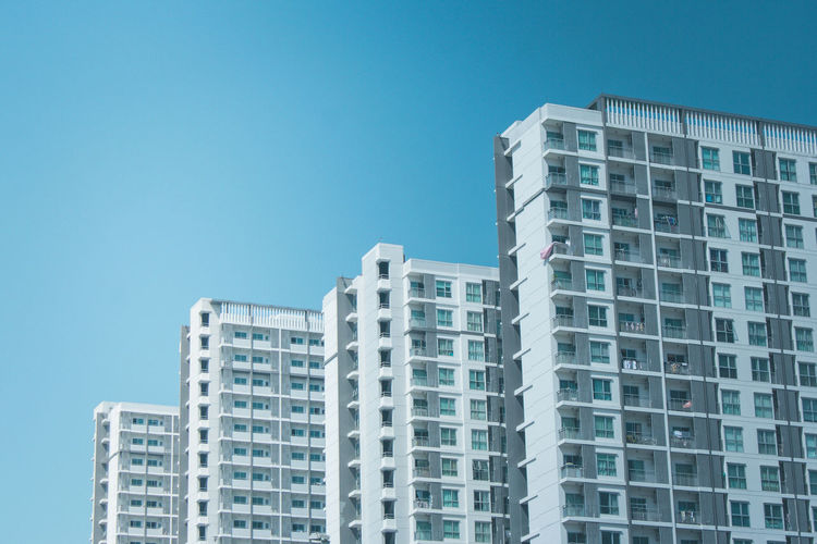 Low angle view of residential buildings against clear blue sky