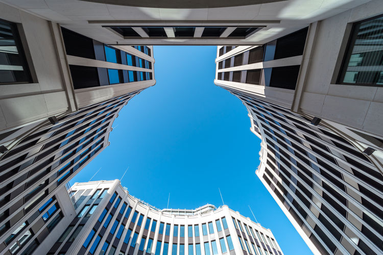 Low angle view of modern buildings against clear blue sky