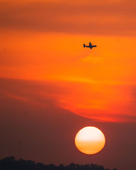 Silhouette airplane against sky during sunset