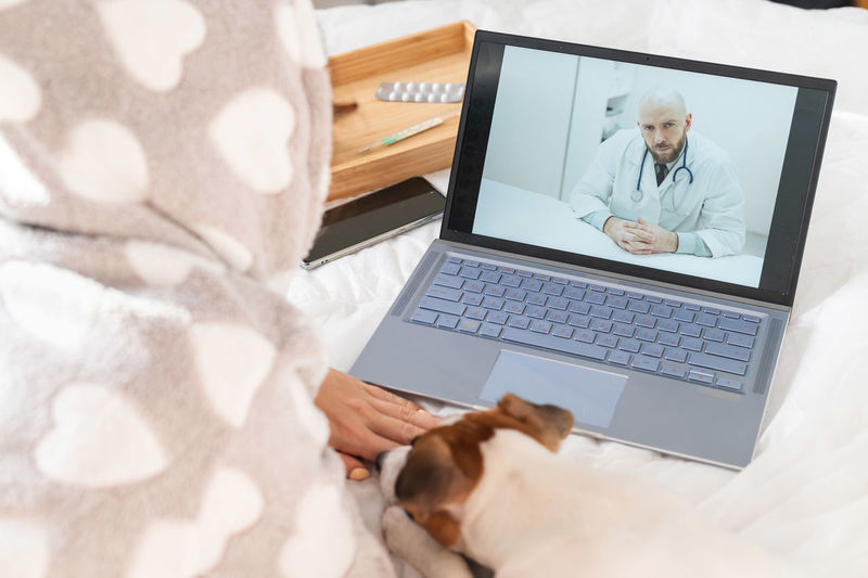 Midsection of woman talking with doctor on video call