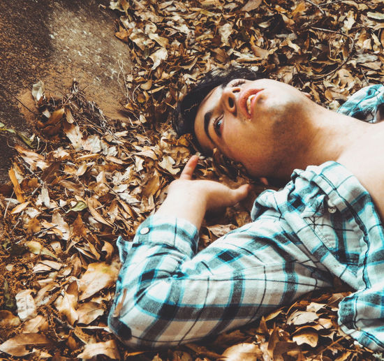 Man lying down on autumn leaves