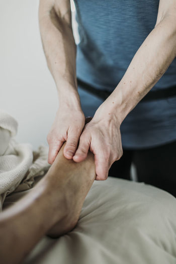 Female therapist uses hands to massage foot of client