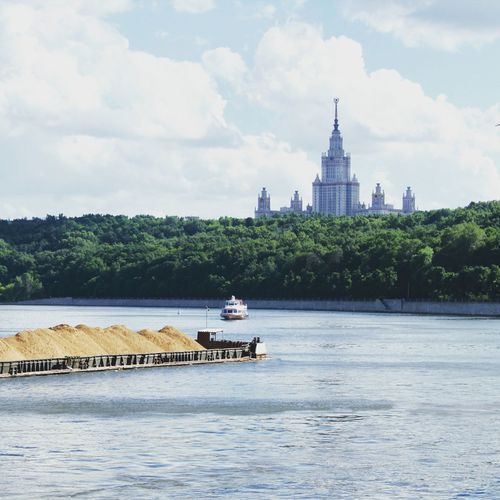 Moscow state university seen from lake against cloudy sky