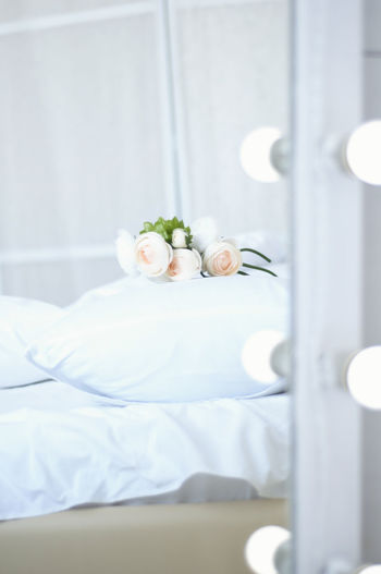 Close-up of white bed with illuminated lights at home