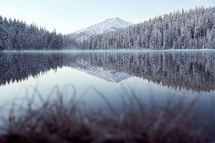 Scenic lake in winter with snow covered trees and mountain