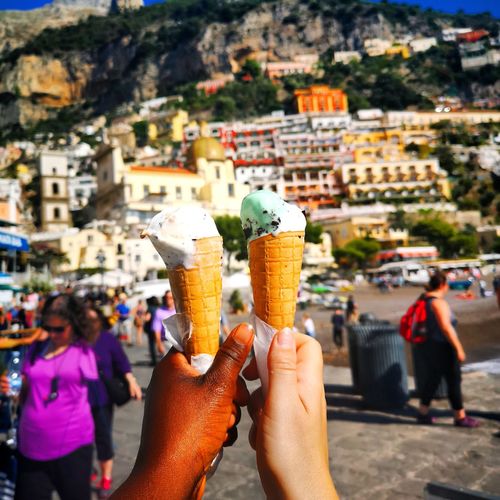 Close-up of man and woman holding ice cream in city
