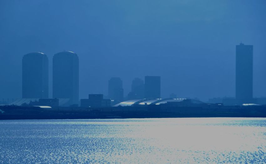 Buildings in city against blue sky