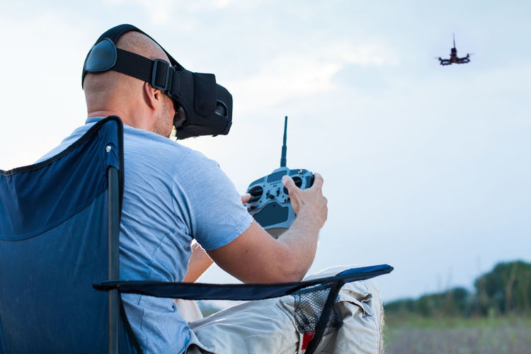 Man using virtual reality simulator while flying drone