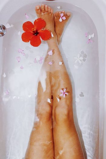 Low section of woman with legs in bathtub