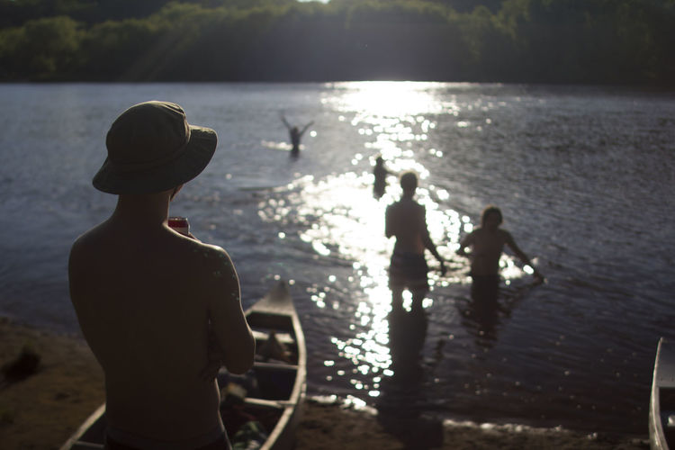 Rear view of silhouette men in river