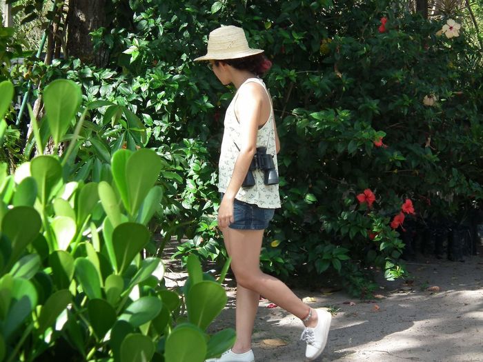 Side view of woman walking by plants