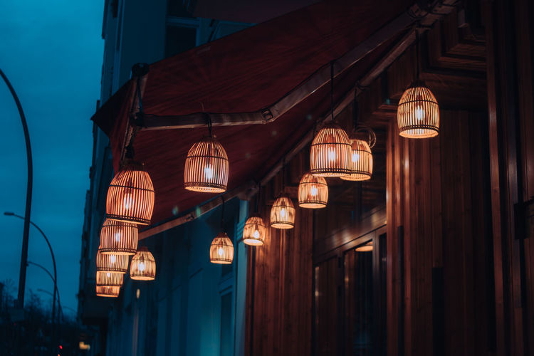 Low angle view of illuminated lanterns hanging on building