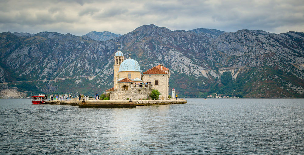 Church amidst lake against mountains