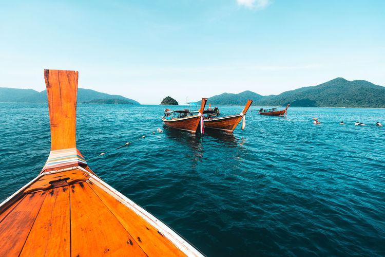 Fishing boat moored at sea against sky