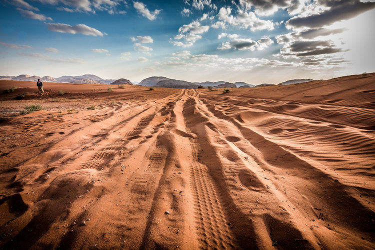 High angle view of sand dunes against dramatic sky