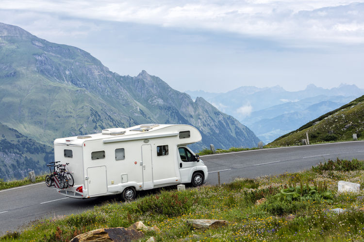 Caravan on mountain road against sky