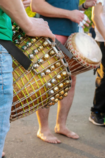 Low section of people playing musical equipment while standing on street