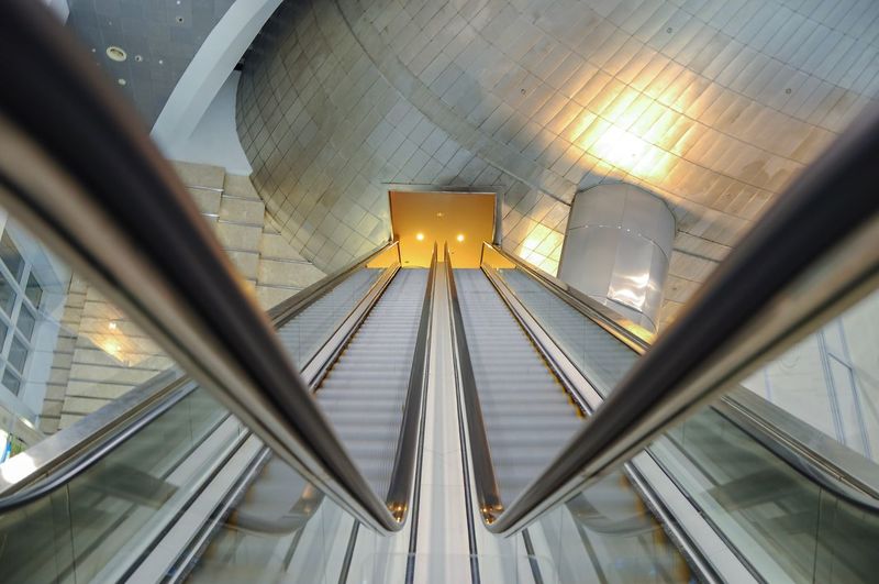 Low angle view of illuminated escalator in building