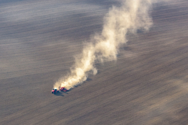 Aerial view of tractor moving on agricultural field
