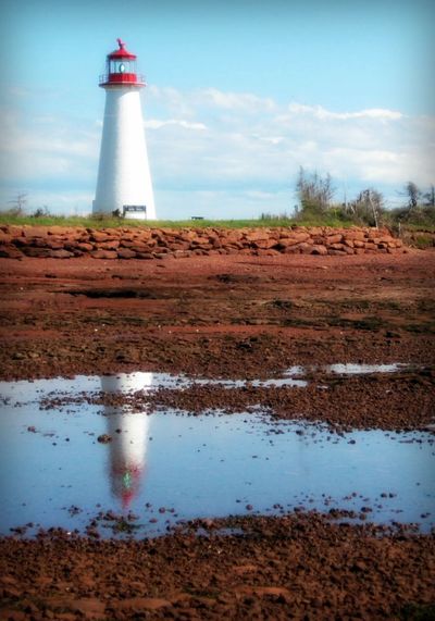Point prim light station reflecting in puddle on field