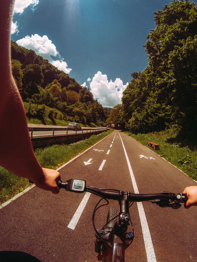 Pov of a man riding electric bicycle on road near the forest
