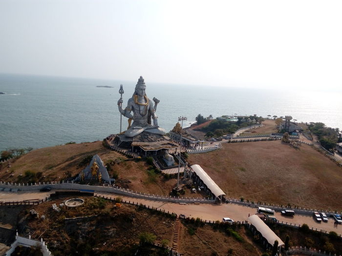 High angle view of statue by sea against clear sky