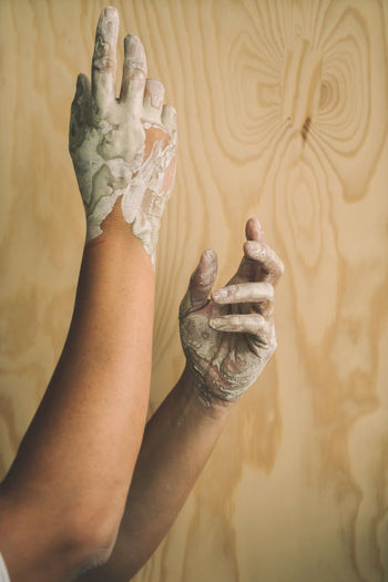 Close-up of woman with messy hands against wall