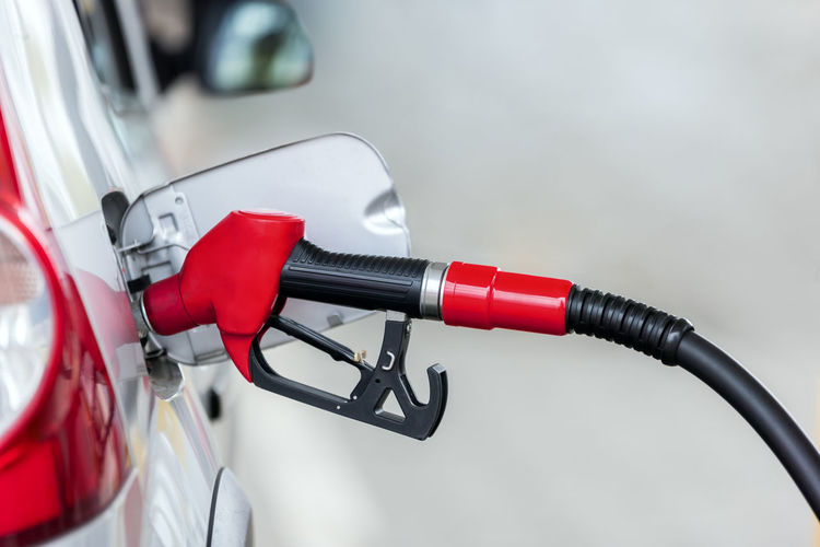 Silver car refuelling at the gas station, the concept of fuel energy