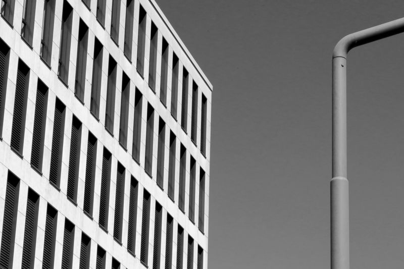 Low angle view of building against clear sky in black and white