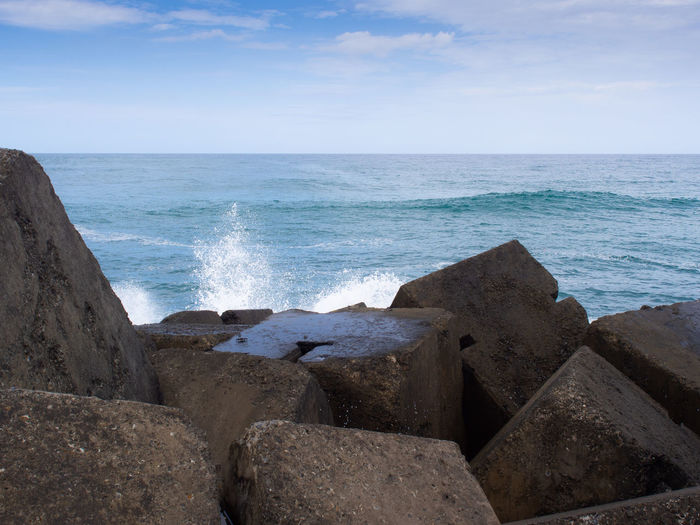 Splash of waves crashing into concrete blocks at the end of the spit